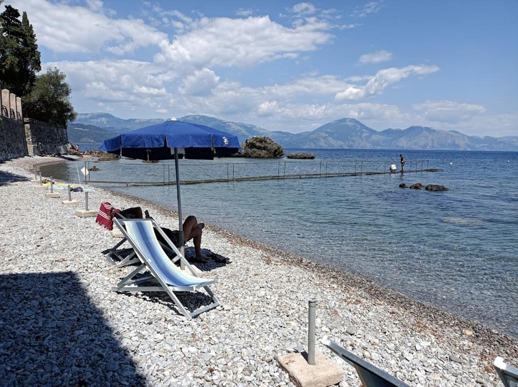 - une plage avec des chaises longues, un parasol et l'eau dans l'établissement La Francesca Sud un villaggio"glamping", à Scario