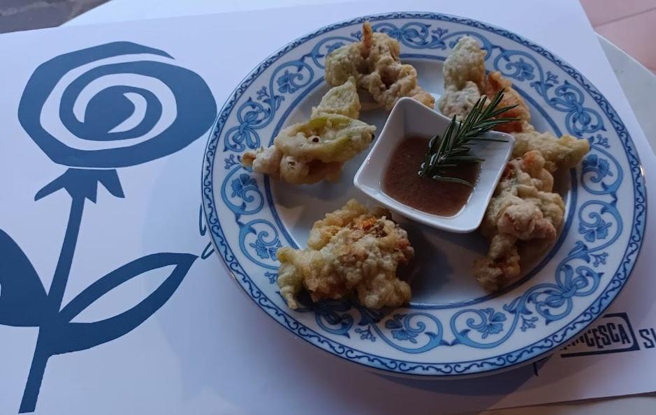 une assiette de nourriture avec des crevettes et une sauce à tremper dans l'établissement La Francesca Sud un villaggio"glamping", à Scario