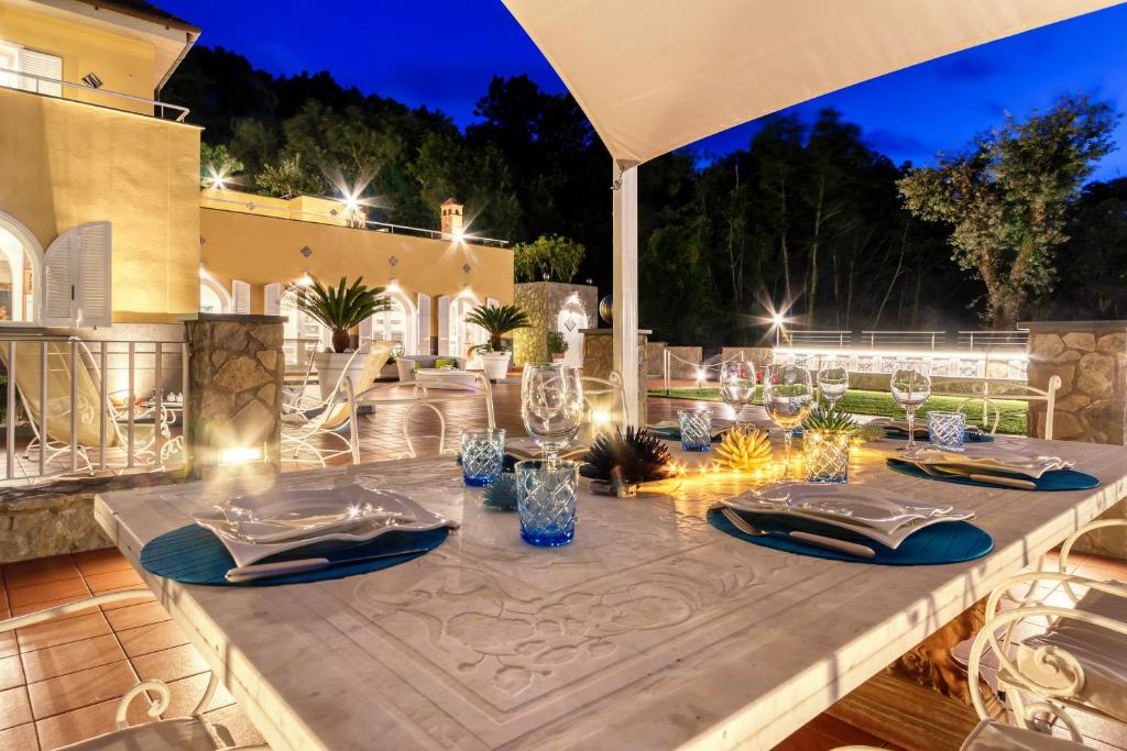 - une table avec des assiettes et des serviettes sur une terrasse la nuit dans l'établissement Villa & SPA Le Tore, à Sorrente