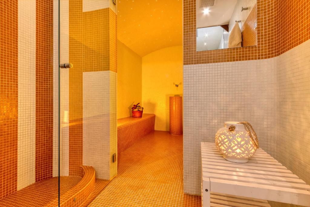 une salle de bain avec une douche et un vase sur un banc dans l'établissement Villa & SPA Le Tore, à Sorrente