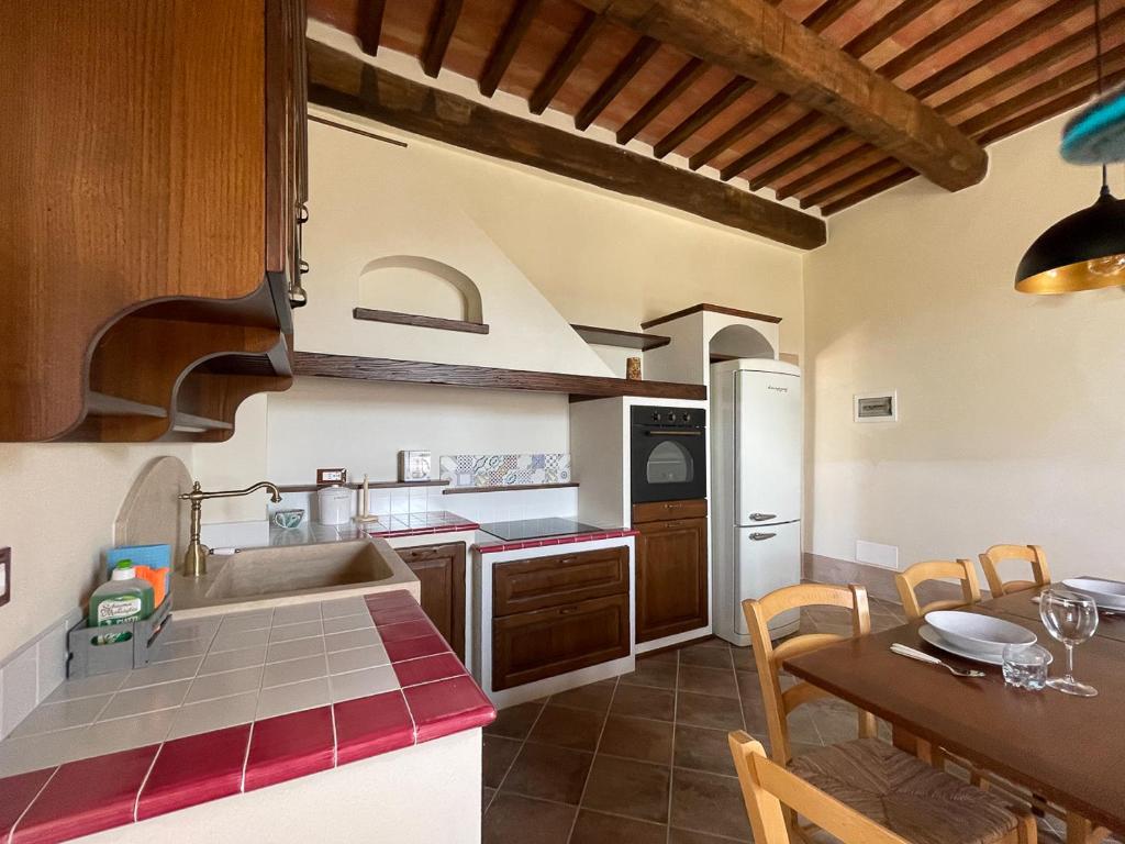 - une cuisine avec un évier et une table avec une salle à manger dans l'établissement Exclusive Villa with pool Borgo Pian di Sala, à San Gimignano