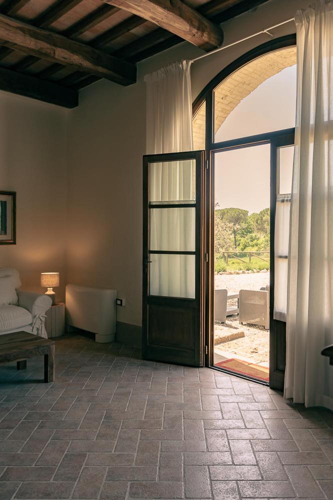 Cette chambre dispose d'une porte ouverte avec un lit et une fenêtre. dans l'établissement Exclusive Villa with pool Borgo Pian di Sala, à San Gimignano 224 autres photos