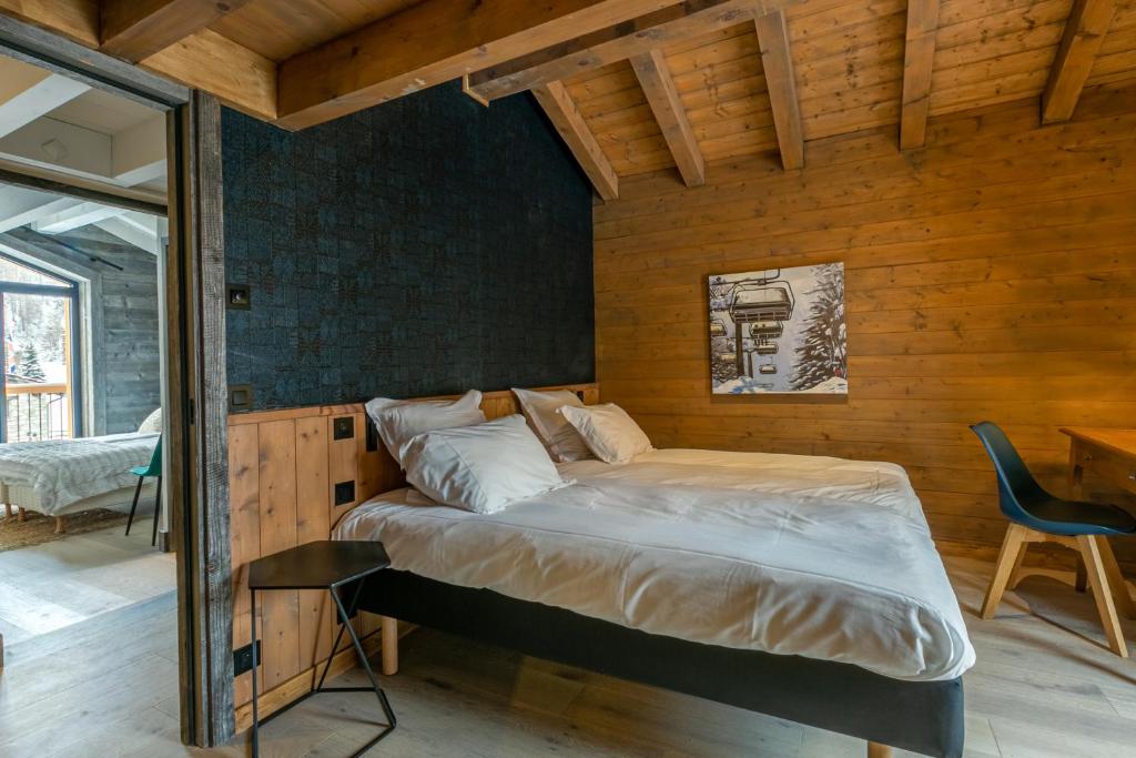 un lit dans une chambre avec un mur en bois dans l'établissement Maisons de montagne Le Samovar, à Val dʼIsère 21 autres photos