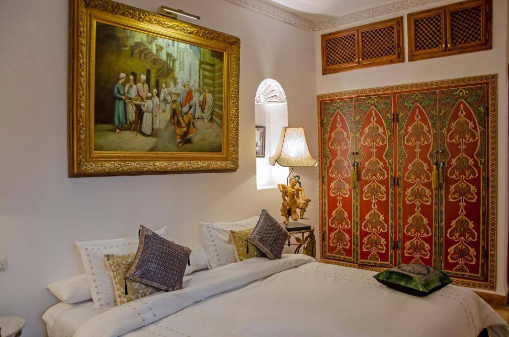 une chambre avec deux lits et un tableau au mur dans l'établissement Riad Esmeralda, à Marrakech