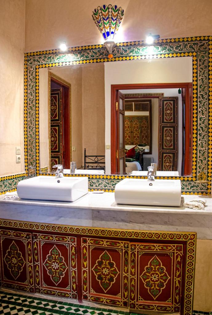 une salle de bain avec deux lavabos et un grand miroir dans l'établissement Riad Esmeralda, à Marrakech 37 autres photos