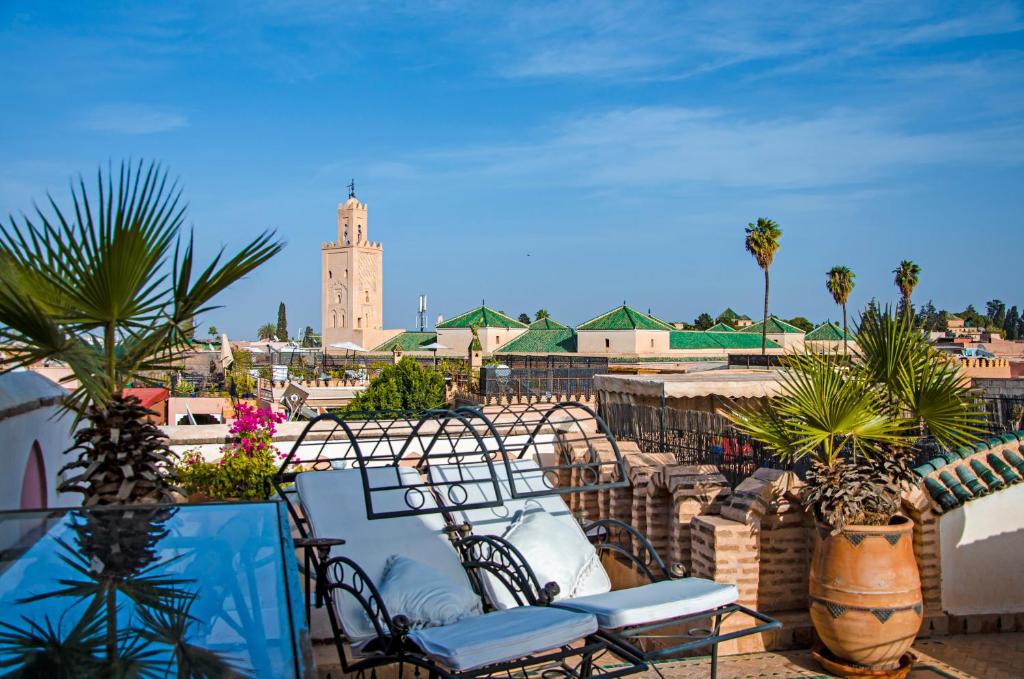 d'un balcon avec des chaises et une tour d'horloge. dans l'établissement Riad Esmeralda, à Marrakech