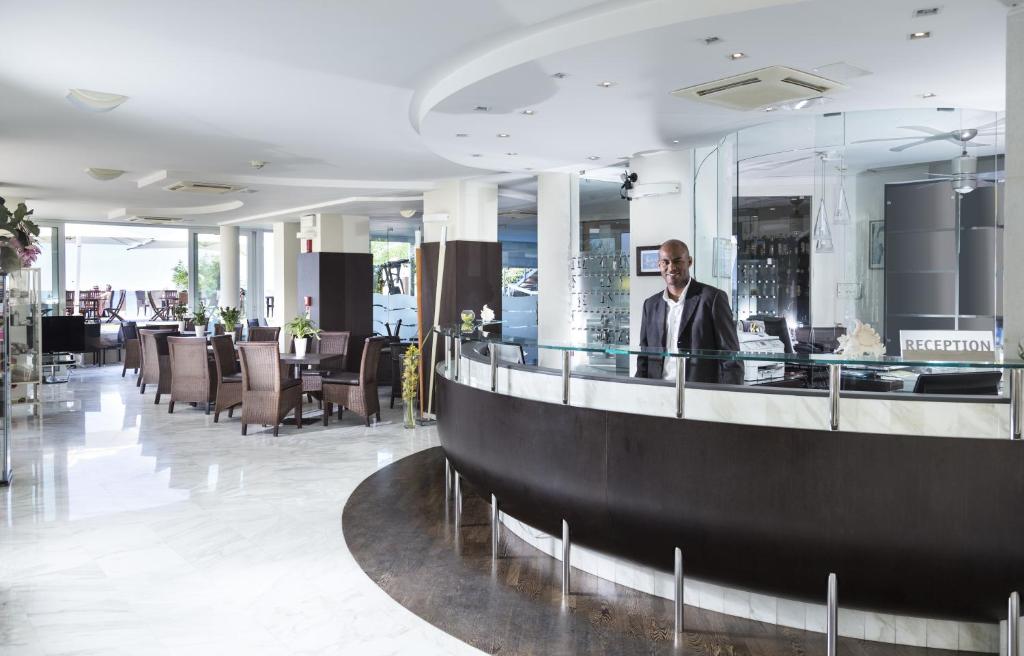 un homme debout à un bar dans le hall d'un hôtel dans l'établissement Hotel Sans Souci, à Gabicce Mare 91 autres photos