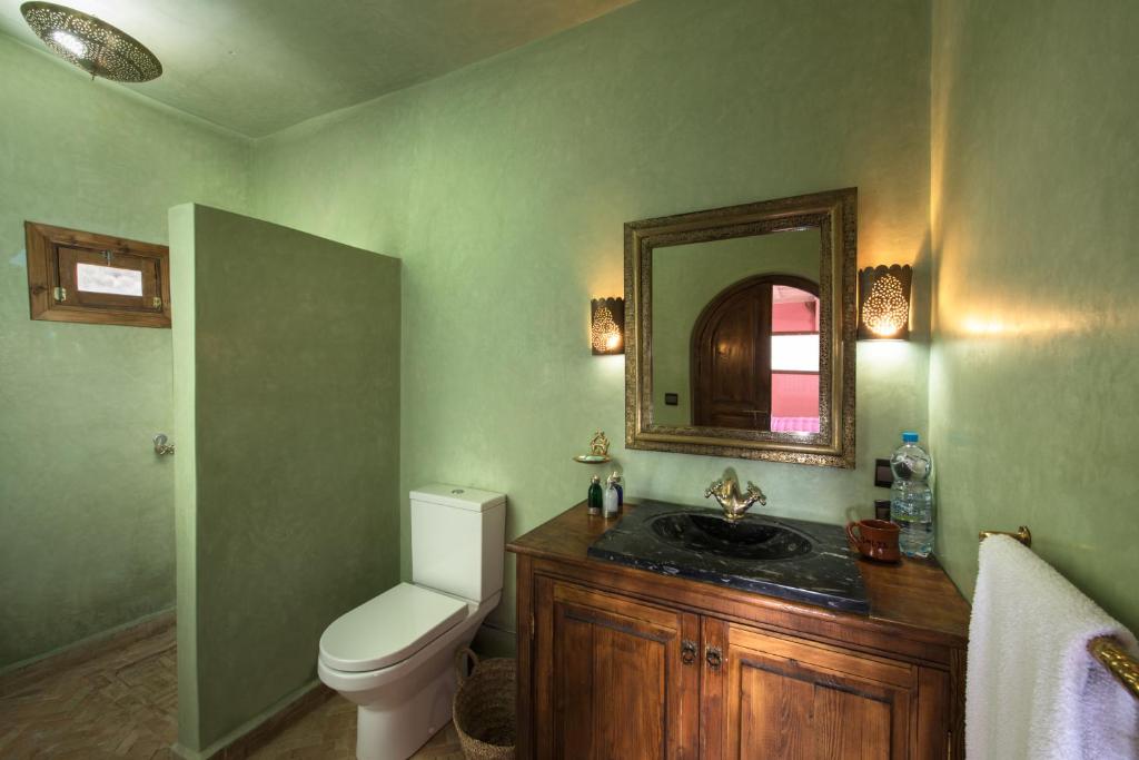 une salle de bain avec toilettes, lavabo et miroir dans l'établissement Imlil Lodge, à Imlil