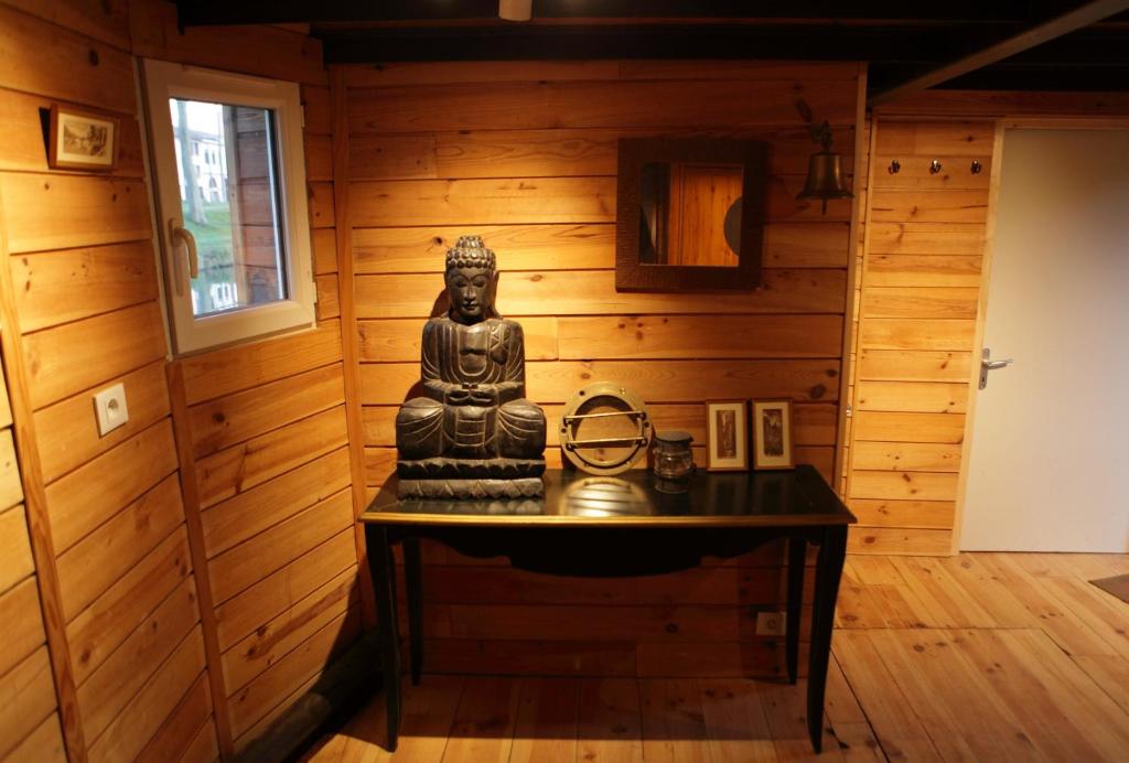 une statue sur une table dans une chambre avec des murs en bois dans l'établissement Péniche Kairos - Havre de paix sur Canal du midi, à Toulouse