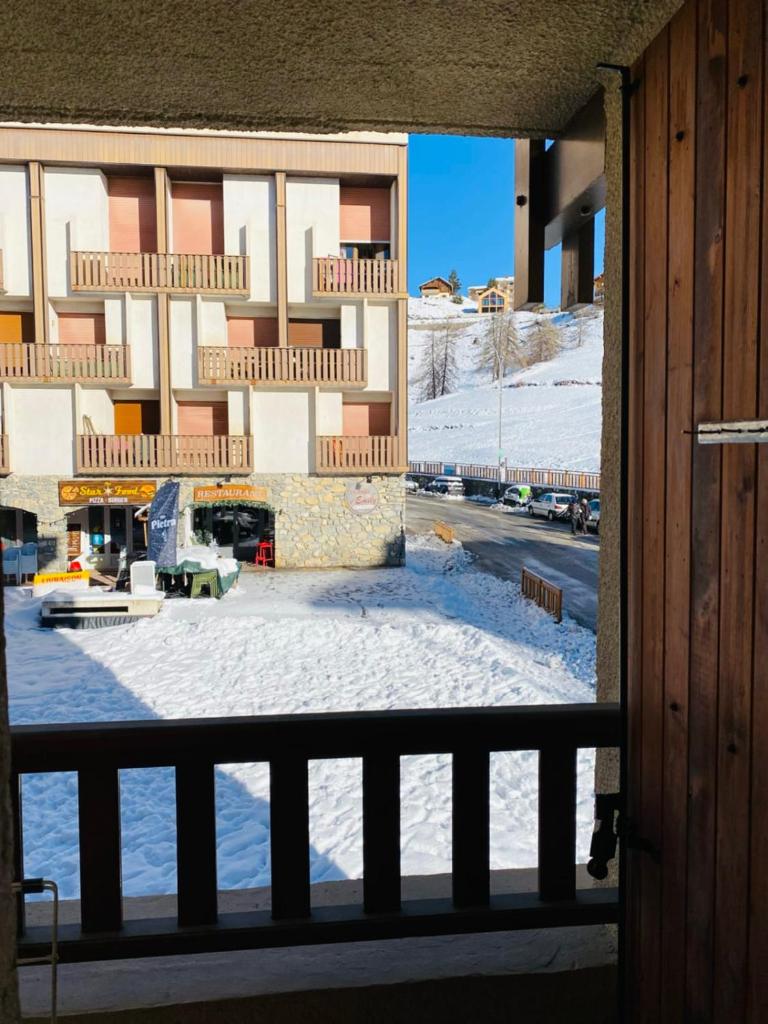 - un balcon offrant une vue sur un bâtiment dans la neige dans l'établissement 2 room apartment in the center close to the slopes, à Valberg 3 autres photos