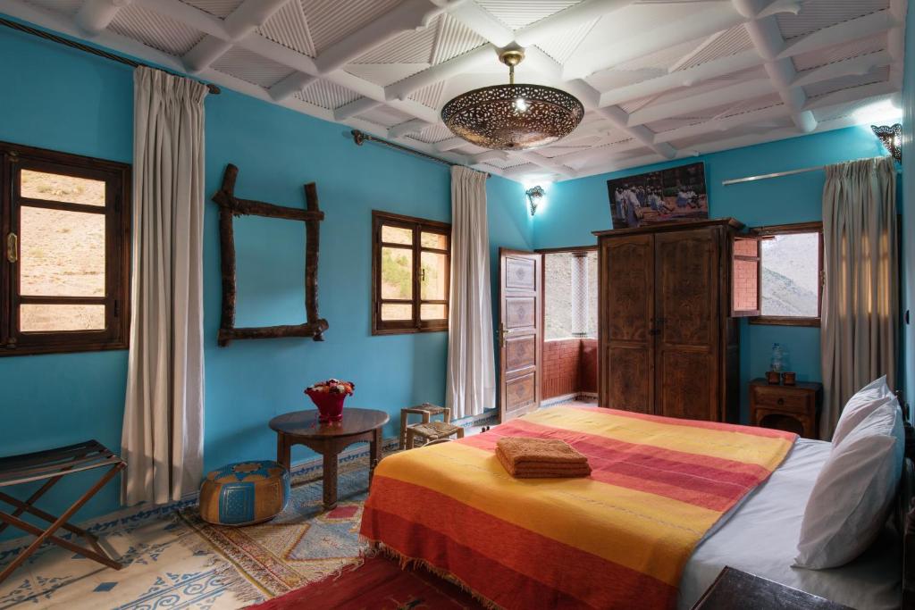 une chambre avec des murs bleus et un grand lit dans l'établissement Imlil Lodge, à Imlil 31 autres photos