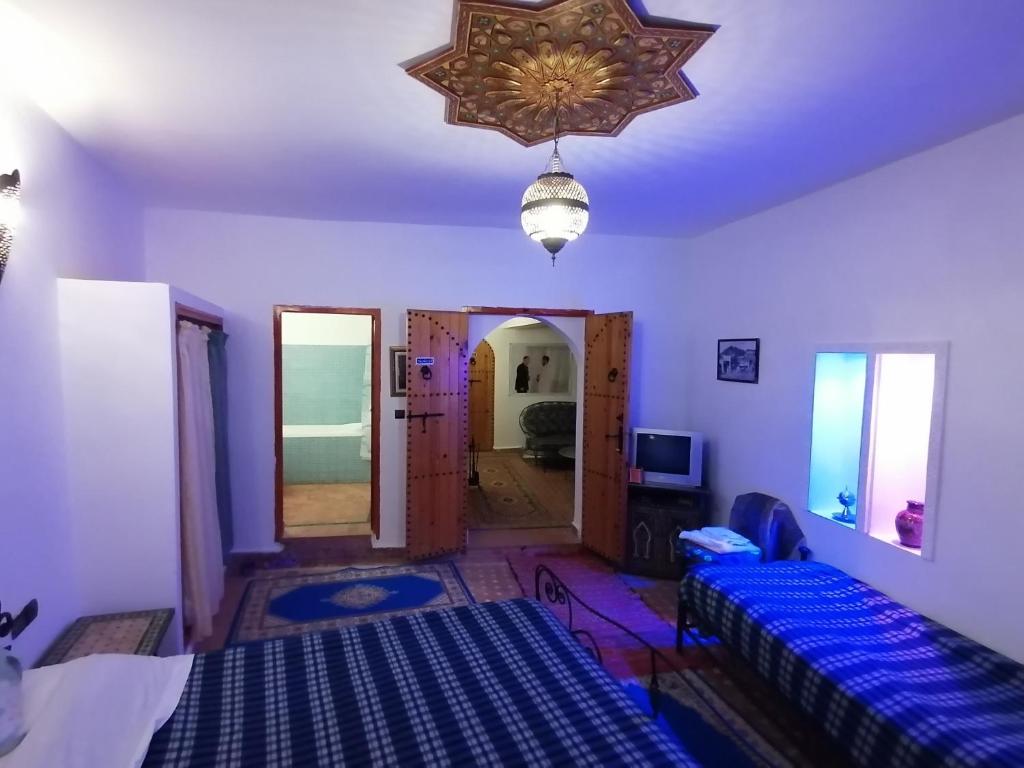 - une chambre avec des murs violets et un lustre dans l'établissement Al Andaloussiya Diyafa, à Moulay Idriss Zerhoun