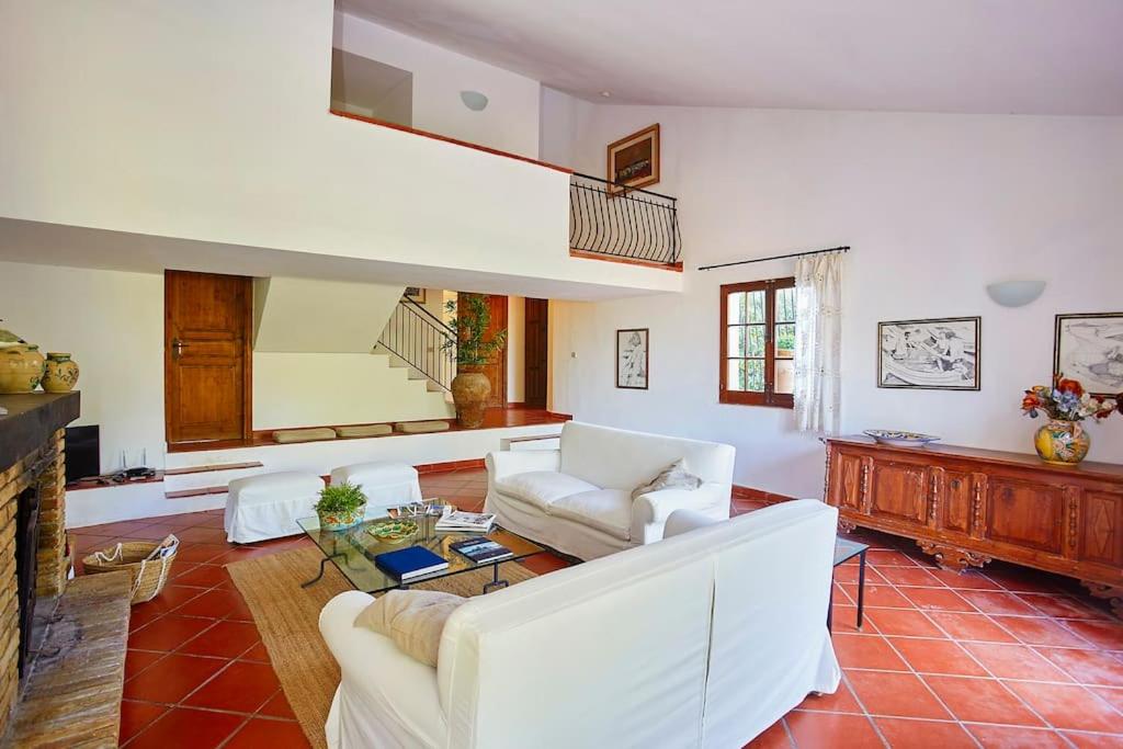 Elle comprend un salon doté d'un mobilier blanc et d'une cheminée. dans l'établissement Villa Maravigghia, à Castellammare del Golfo