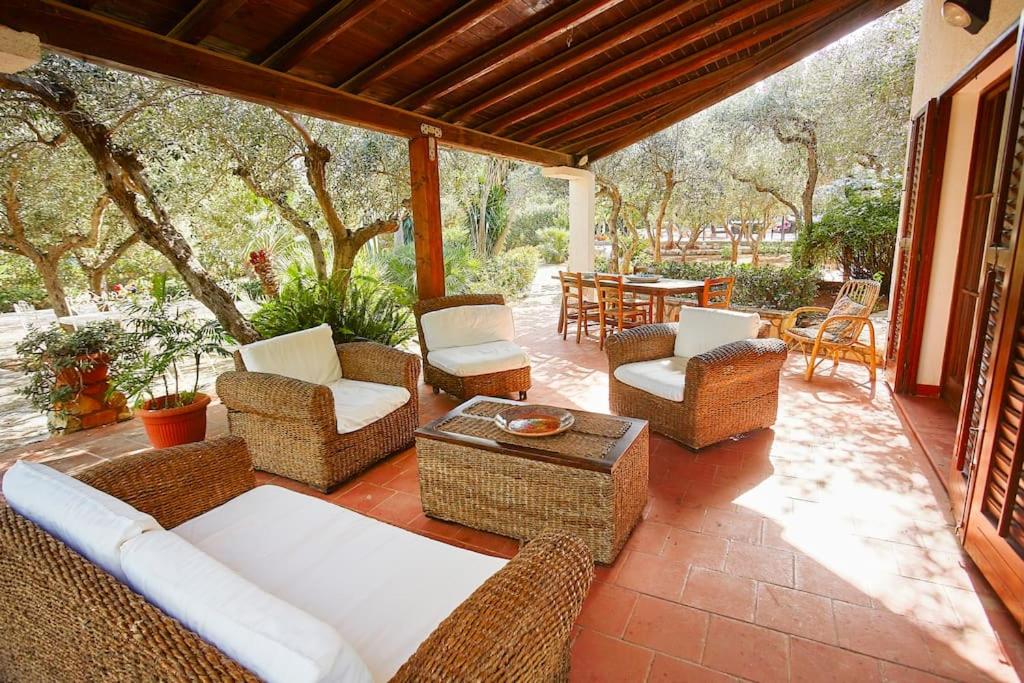 d'une terrasse avec des meubles en osier, une table et des chaises. dans l'établissement Villa Maravigghia, à Castellammare del Golfo