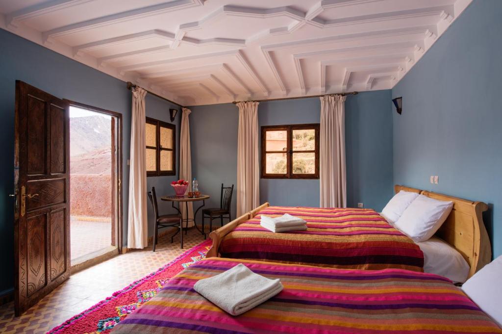 une chambre avec deux lits dans une pièce dans l'établissement Imlil Lodge, à Imlil