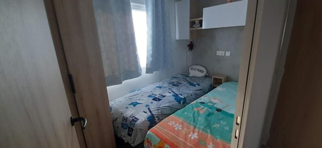 une petite chambre avec un lit et une fenêtre dans l'établissement Le lac des rêves à Lattes, à Lattes