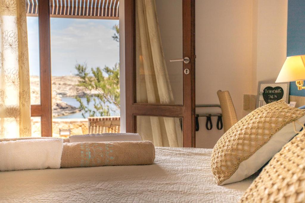 une chambre avec un lit avec vue sur une plage dans l'établissement Relais Isole del Sud, à Lampedusa