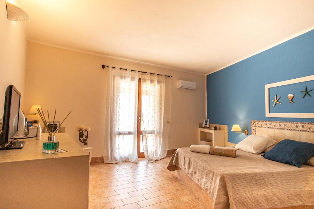 une chambre avec des murs bleus et un lit et une télévision dans l'établissement Relais Isole del Sud, à Lampedusa 44 autres photos