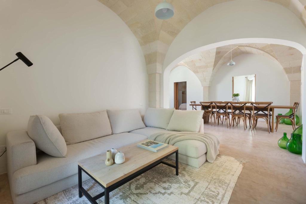 un salon avec un canapé blanc et une table dans l'établissement Casa Diora by Perle di Puglia, à Carovigno