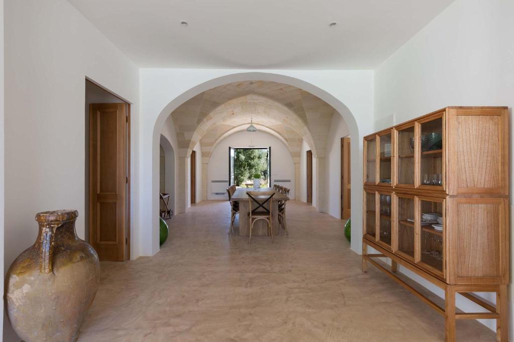 une salle à manger avec une table et un vase dans l'établissement Casa Diora by Perle di Puglia, à Carovigno 65 autres photos