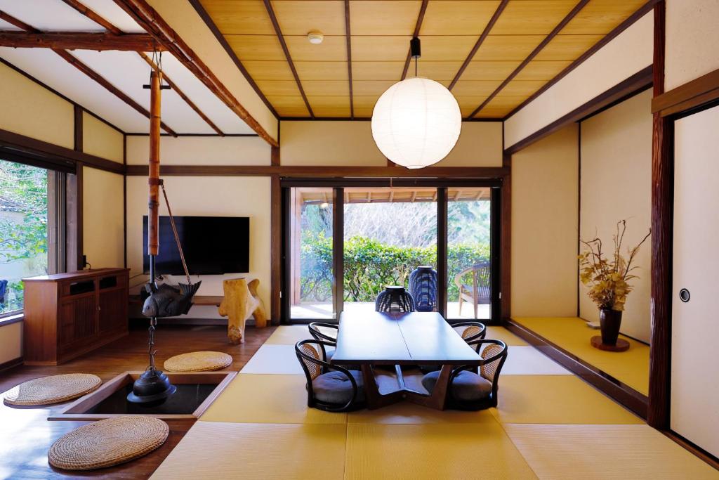 un salon avec une table et des chaises dans l'établissement Sakahijiri gyokushoen, à Izu