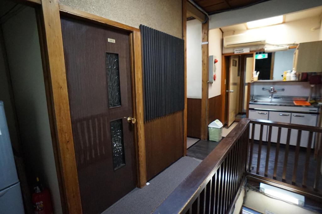 un couloir vide avec une porte et une cuisine dans l'établissement Ryokan Katsutaro, à Tokyo