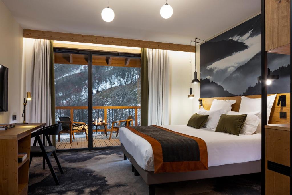une chambre d'hôtel avec un lit et un balcon dans l'établissement HIGALIK HOTEL, aux Menuires