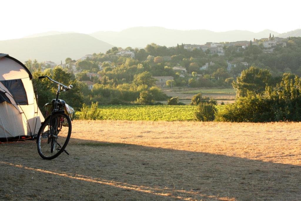 un vélo garé à côté d'une tente dans un champ dans l'établissement Le Mas Cauvy, à Saint-Christol-lès-Alès