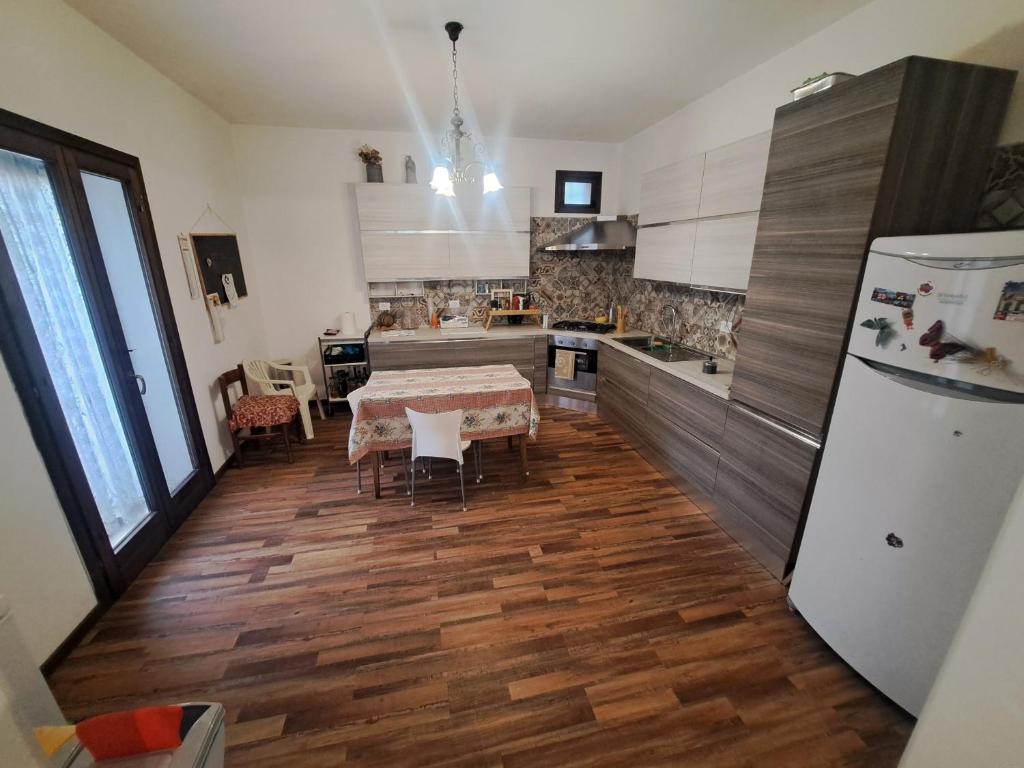 une cuisine avec une table et un réfrigérateur dans l'établissement Casa nel verde a Monterotondo, à Cretone