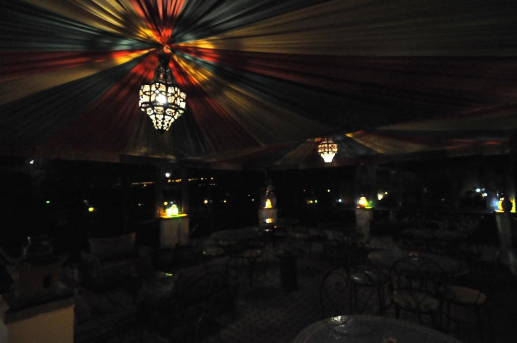 une chambre avec des lumières et des lustres dans une tente dans l'établissement Riad Khouloud, à Fès