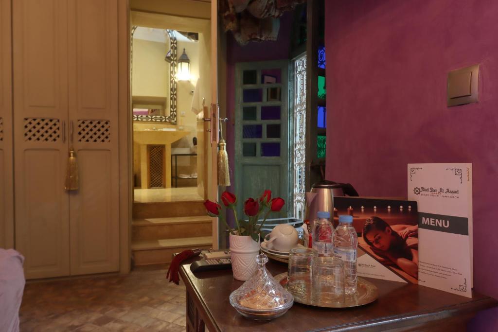 Cette chambre comprend une table avec des bouteilles et des fleurs. dans l'établissement Riad Dar Al Assad, à Marrakech