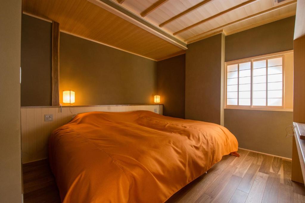 une chambre avec un lit avec une couverture orange dans l'établissement Yatsusankan Over 6 years old, à Hida 63 autres photos