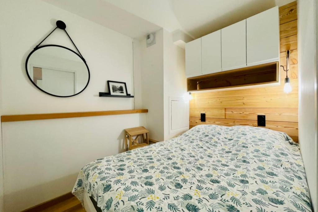 une chambre avec un lit et un miroir au mur dans l'établissement Serre-ChevalierStudio Terrace next to ski slopes, à Saint-Chaffrey