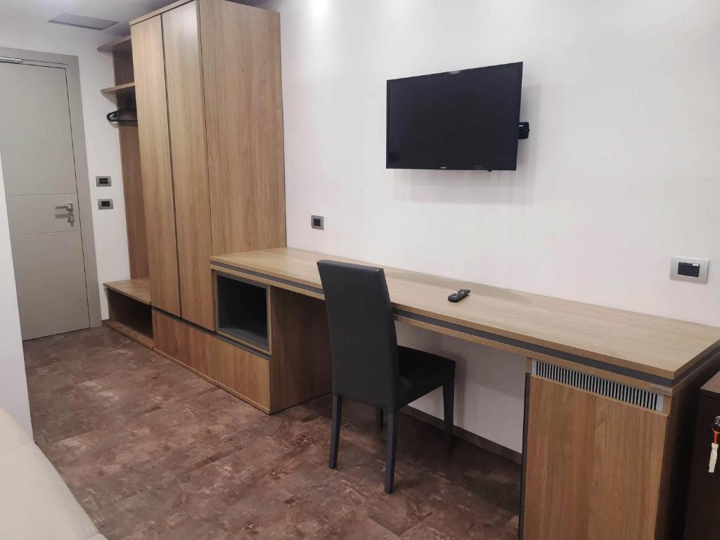 une pièce avec un bureau avec une télévision sur un mur dans l'établissement Hotel Miramare, à Cirò Marina