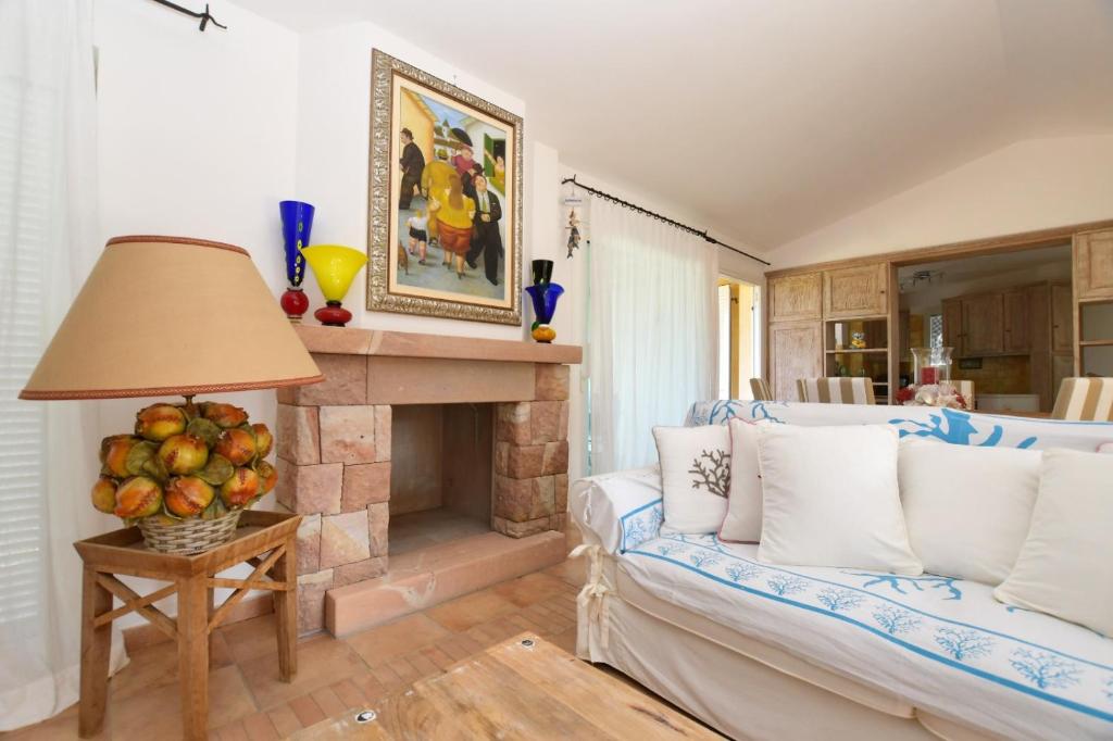 un salon avec un canapé et une cheminée dans l'établissement [Villa indipendente piscina privata] e vista mare, à Cala Bitta