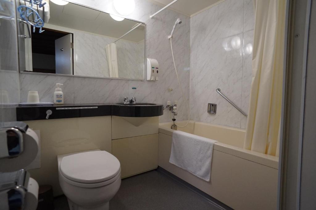 une salle de bain avec toilettes, lavabo et baignoire dans l'établissement Ryokan Katsutaro, à Tokyo