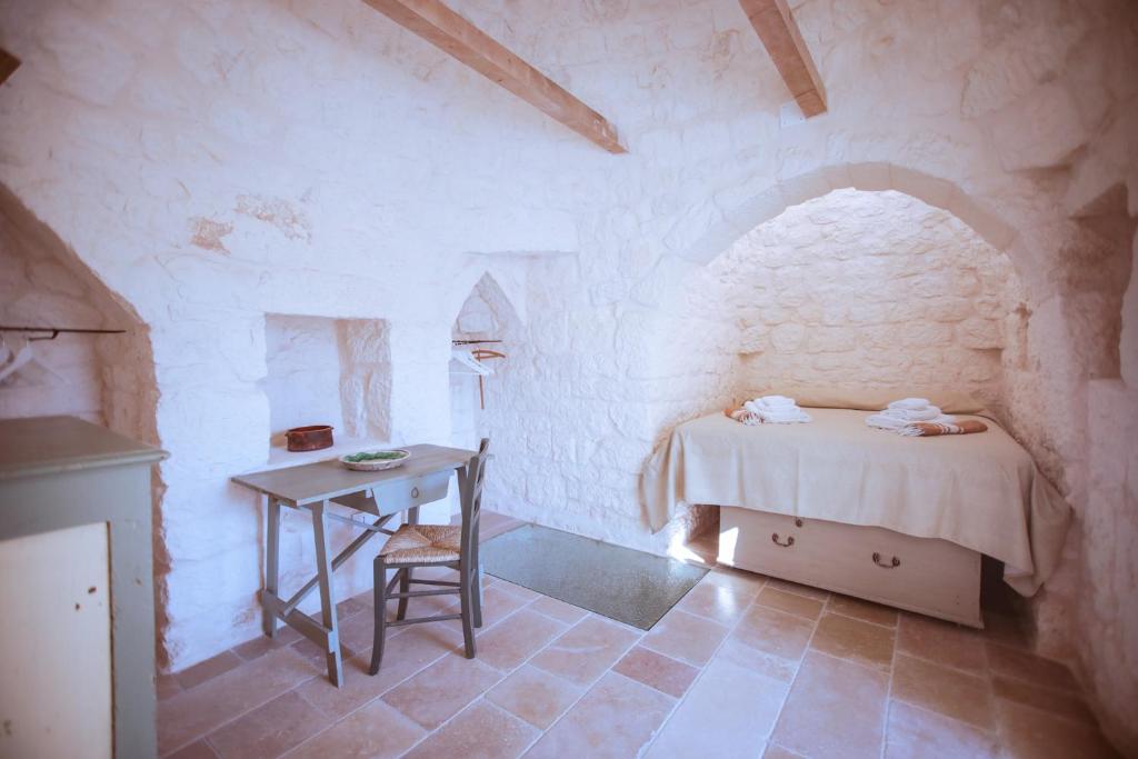une petite chambre avec un lit et une table dans l'établissement Trullo Mamas, à Ostuni