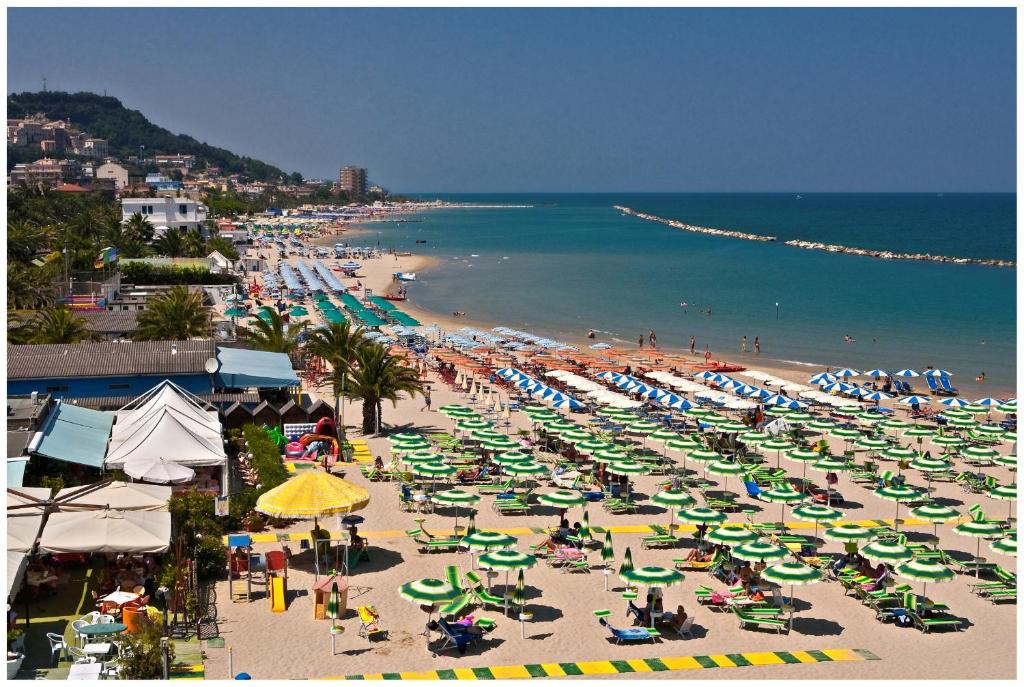 - une plage avec beaucoup de chaises et de parasols dans l'établissement Hotel La Perla Preziosa, à Grottammare