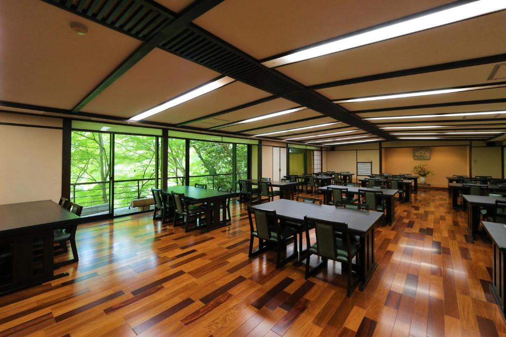 une salle à manger avec tables, chaises et fenêtres dans l'établissement Momijiya Honkan Takaosansou, à Kyoto