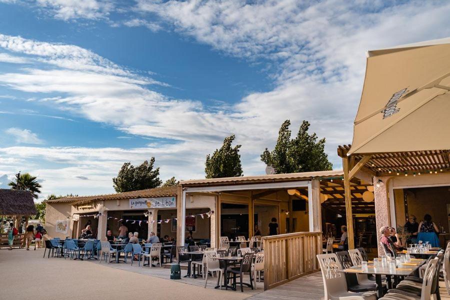 un restaurant avec des tables et des chaises sur une terrasse dans l'établissement MOBIL HOME Au PRECIEUX, à Valras-Plage