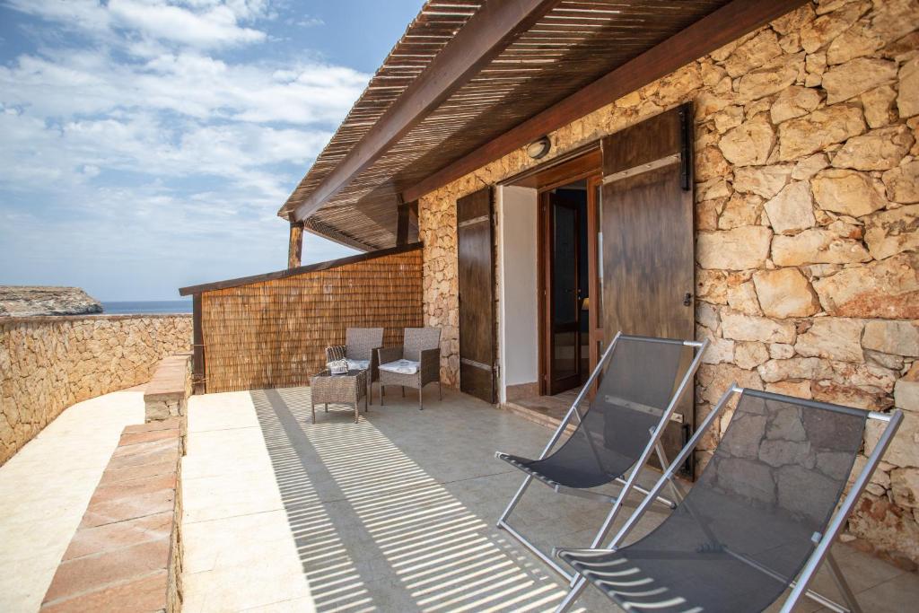 un patio avec des chaises et une table dans un bâtiment dans l'établissement Relais Isole del Sud, à Lampedusa
