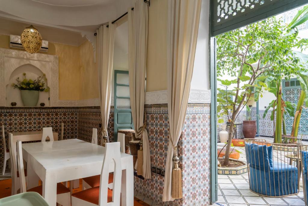 une salle à manger avec une table blanche et une terrasse dans l'établissement Riad Orange, à Marrakech
