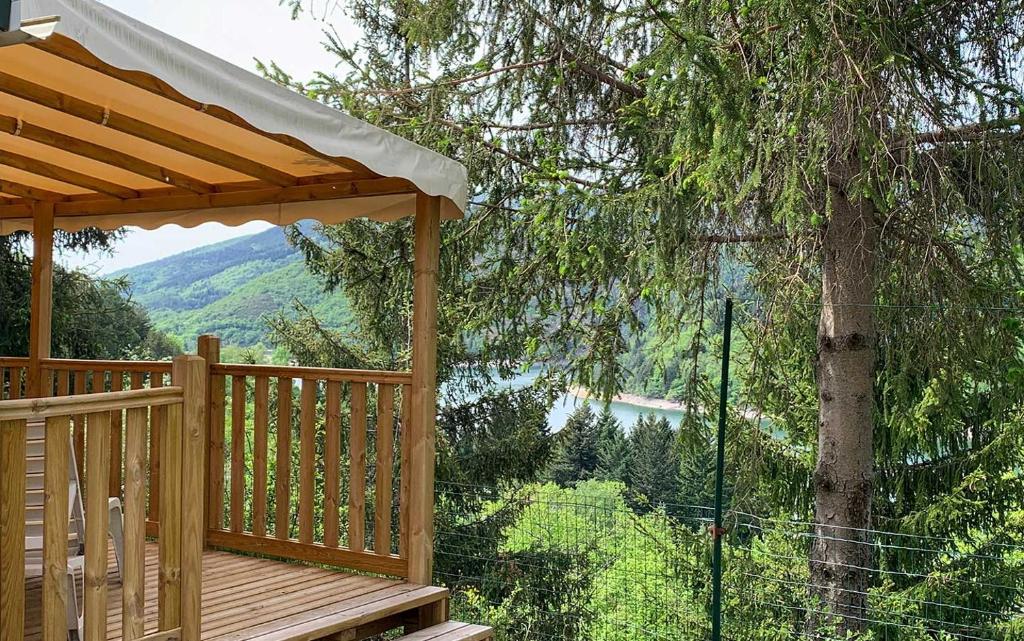 une terrasse en bois avec vue sur le lac dans l'établissement Camping Lac de Villefort, à Villefort