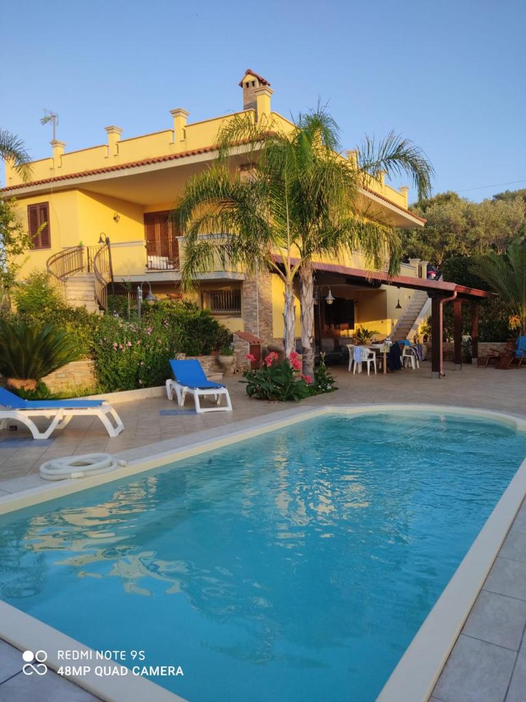 une maison avec une piscine devant une maison dans l'établissement Villa Summer, à Trappeto
