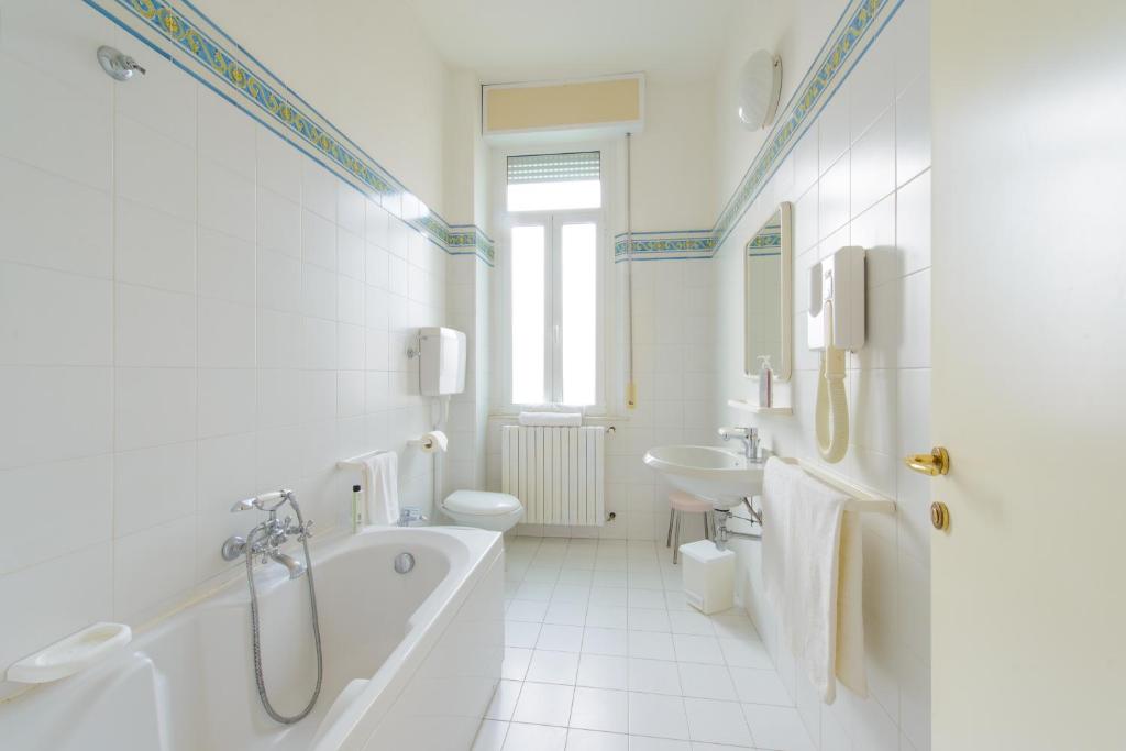 une salle de bain avec une baignoire, des toilettes et un lavabo dans l'établissement Palace Hotel Domus Mea Riccione, à Riccione