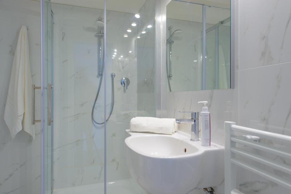 une salle de bain blanche avec lavabo et douche dans l'établissement Palace Hotel Domus Mea Riccione, à Riccione 65 autres photos