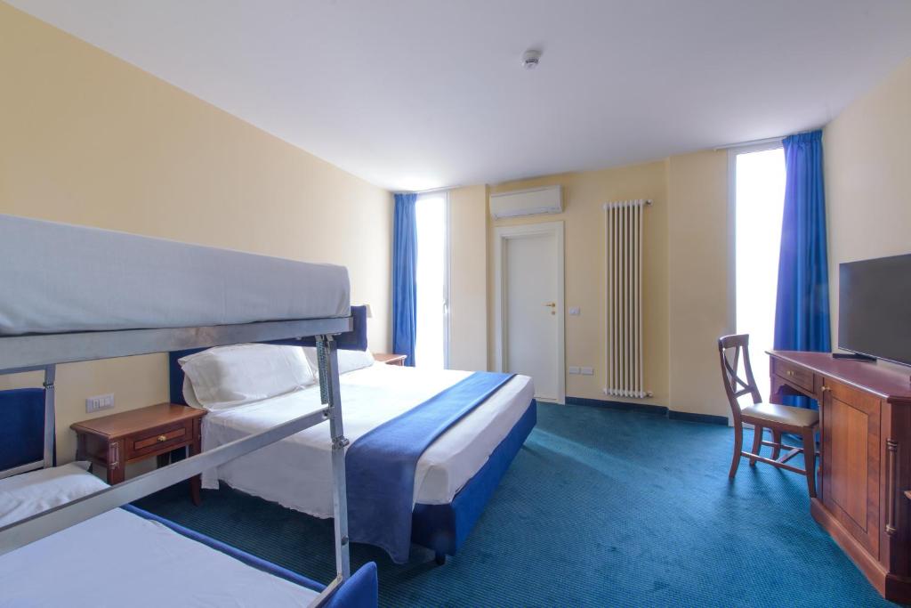 - une chambre avec des lits superposés, un bureau et une télévision dans l'établissement Palace Hotel Domus Mea Riccione, à Riccione