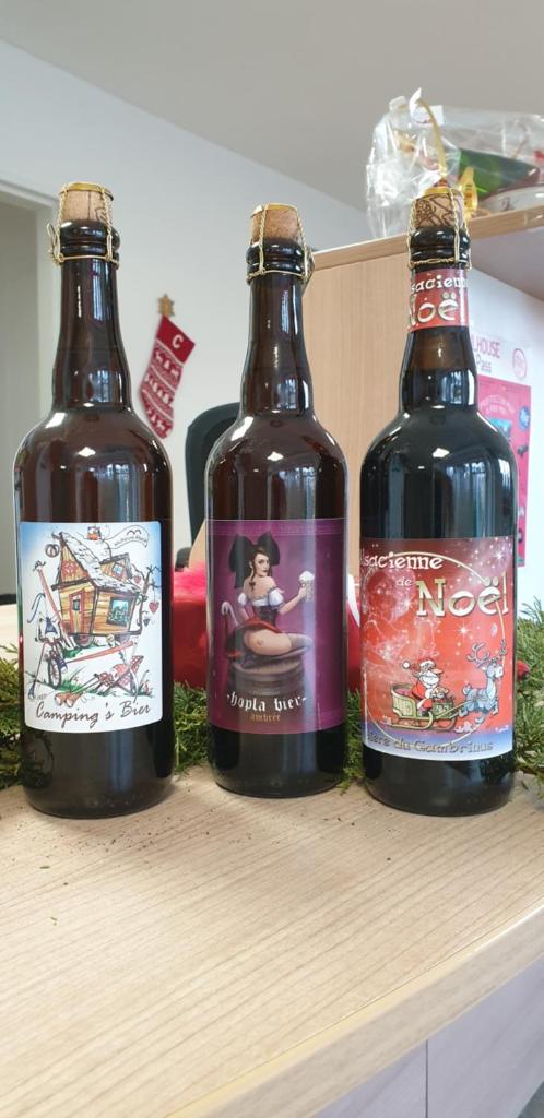 trois bouteilles de bière assises sur une étagère en bois dans l'établissement Camping de l'Ill, à Mulhouse