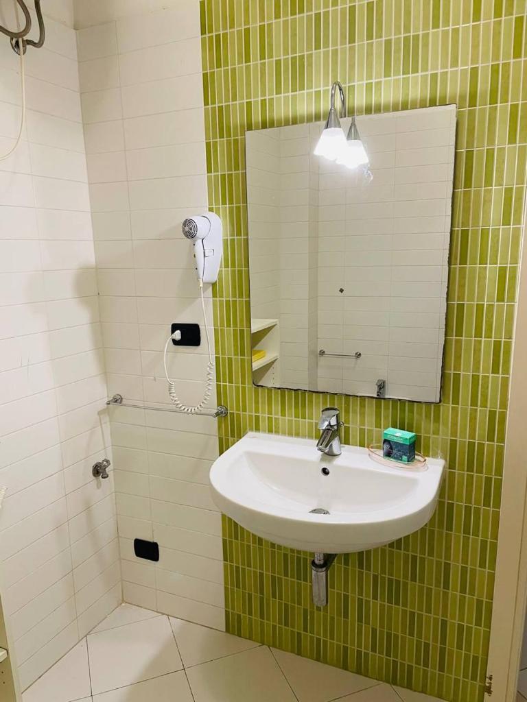 une salle de bain avec un lavabo et un miroir dans l'établissement Regina Del Mare Holiday Apartments, à Tirrenia 63 autres photos