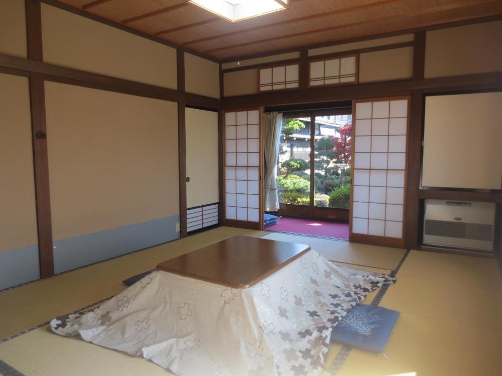 une chambre avec une table au milieu d'une pièce dans l'établissement Shitanda, à Takayama